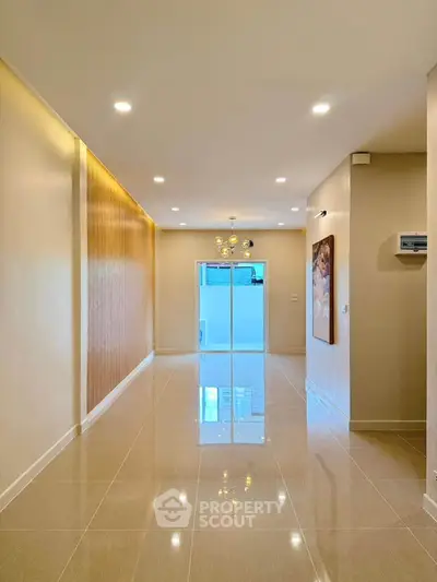 Spacious modern living room with elegant lighting and glossy tiled floors