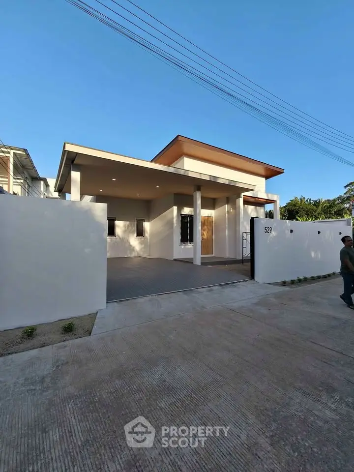 Modern single-story house with sleek design and spacious driveway, perfect for contemporary living.