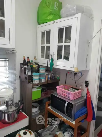 Cozy kitchen with microwave, cabinets, and organized storage space.