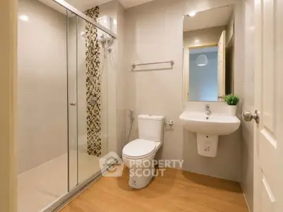 Modern bathroom with glass shower, sleek fixtures, and stylish tile accents.