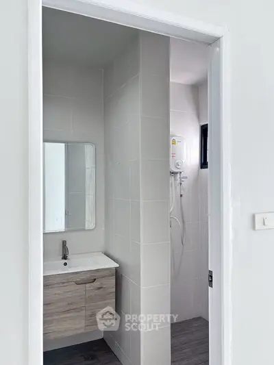 Modern bathroom with sleek vanity and shower in minimalist design.