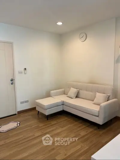 Cozy living room with modern white sofa and wooden flooring