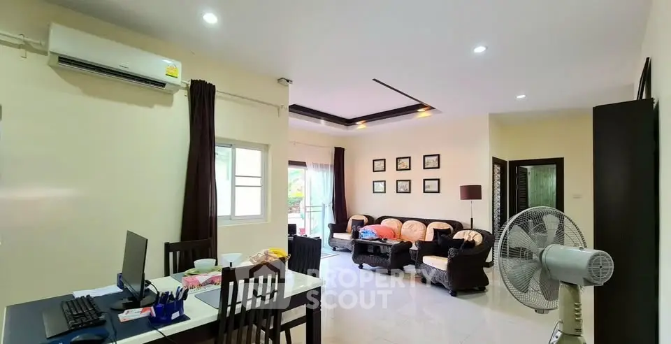Spacious living room with modern decor and ample natural light, perfect for family gatherings.