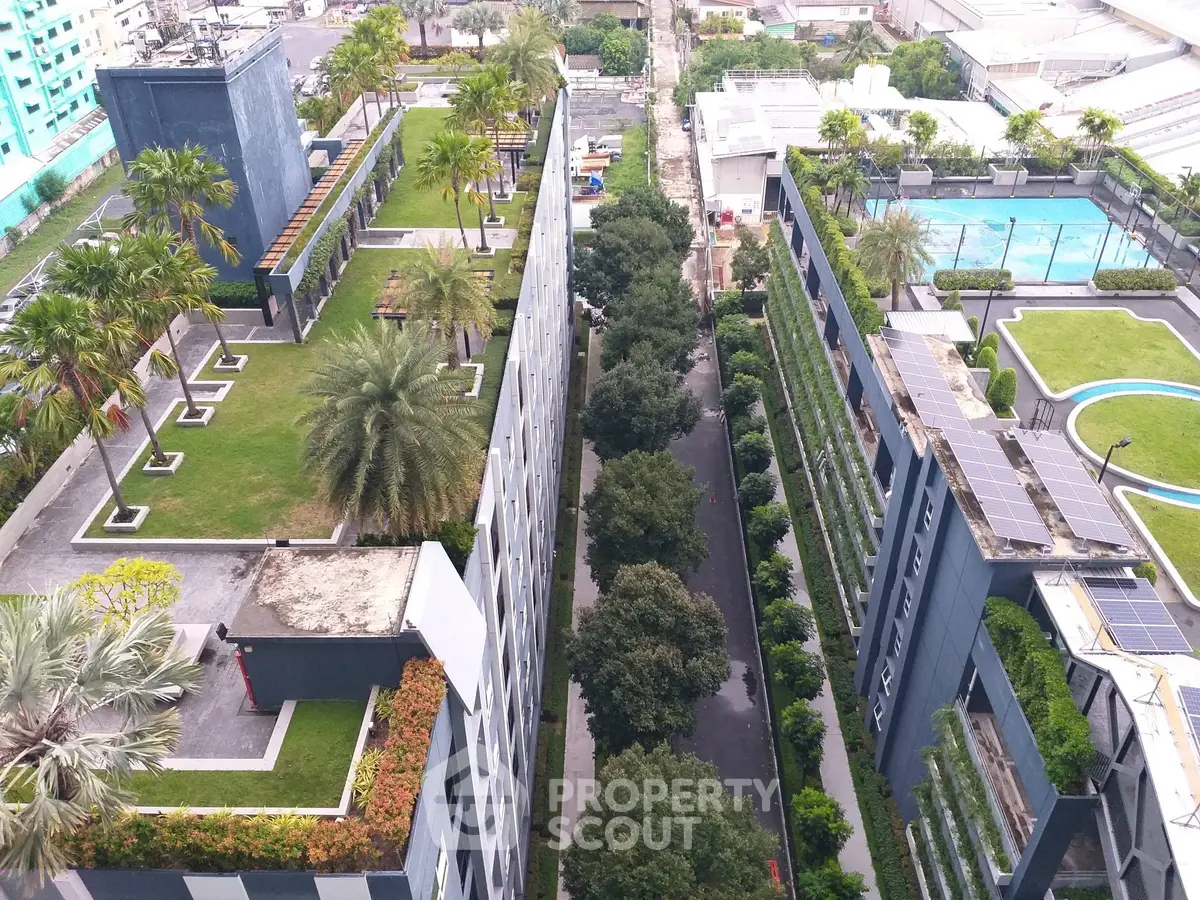 Stunning aerial view of modern apartment complex with lush rooftop gardens and pool area.