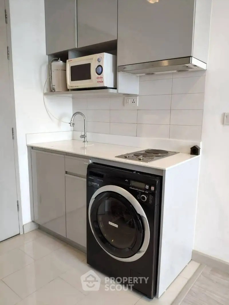 Modern compact kitchen with built-in appliances and sleek cabinetry