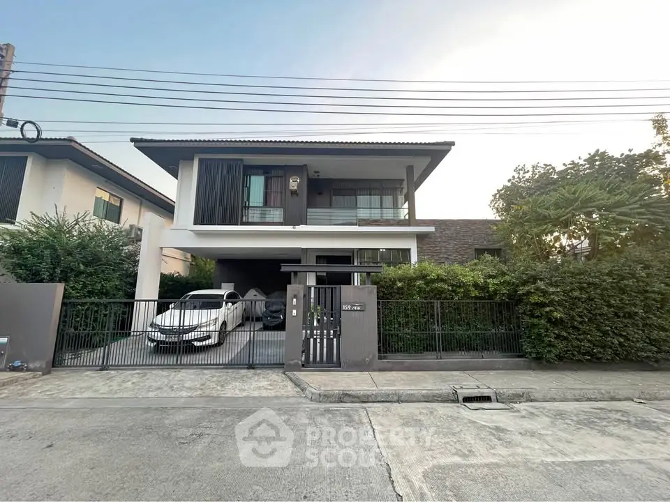 Modern two-story house with sleek design and spacious driveway in a serene neighborhood.