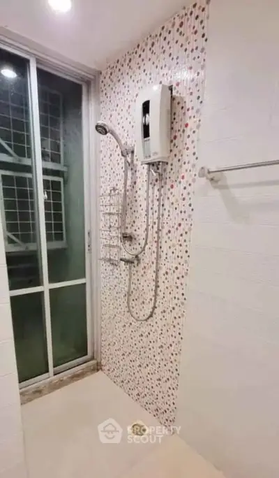Modern bathroom with shower and sliding glass door in stylish apartment.