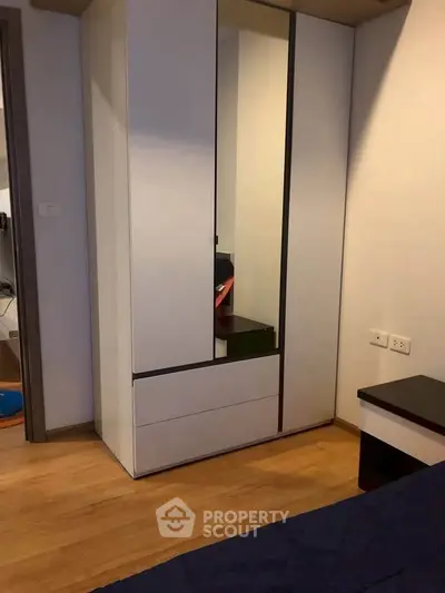 Modern bedroom with sleek wardrobe and wooden flooring