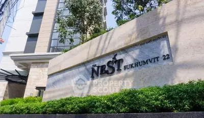 Modern building entrance with lush greenery at The Nest Sukhumvit 22.
