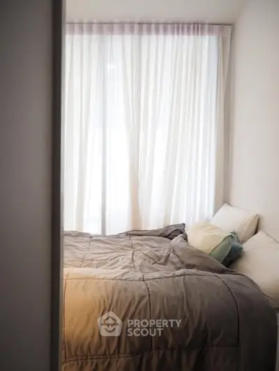 Cozy bedroom with soft lighting and elegant curtains, perfect for relaxation and comfort.
