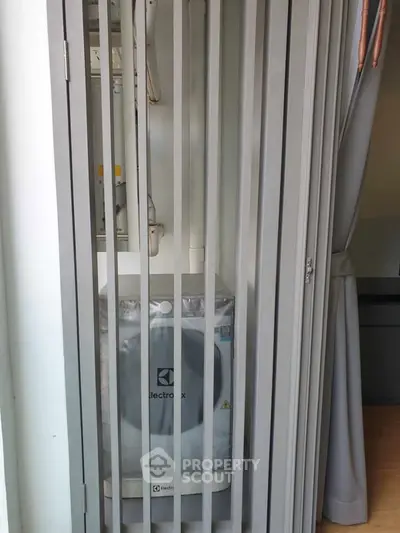 Compact laundry area with Electrolux washing machine in modern apartment