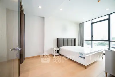 Spacious modern bedroom with large windows and natural light