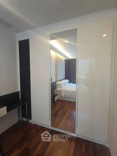 Modern bedroom with sleek wardrobe and wooden flooring