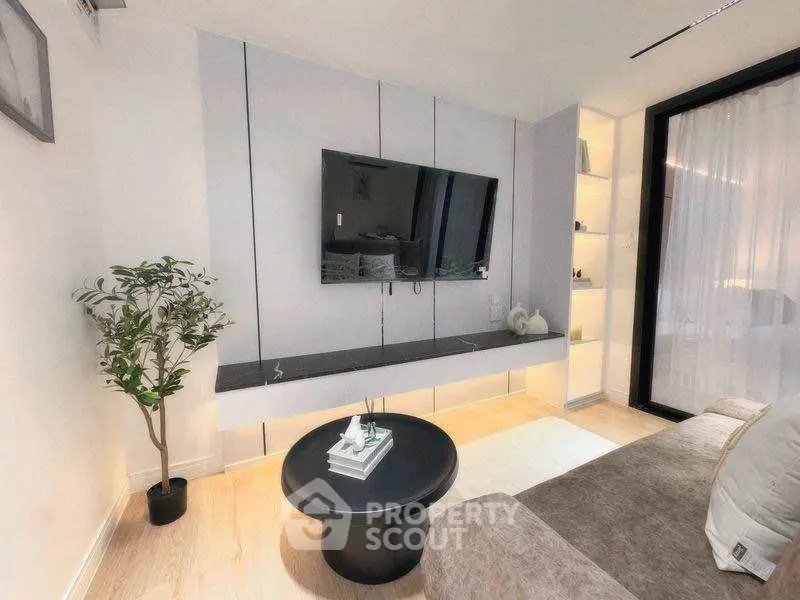 Modern living room with sleek TV setup and cozy seating area.