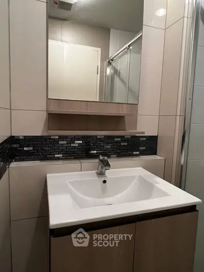 Modern bathroom with sleek vanity and mirror in contemporary design.