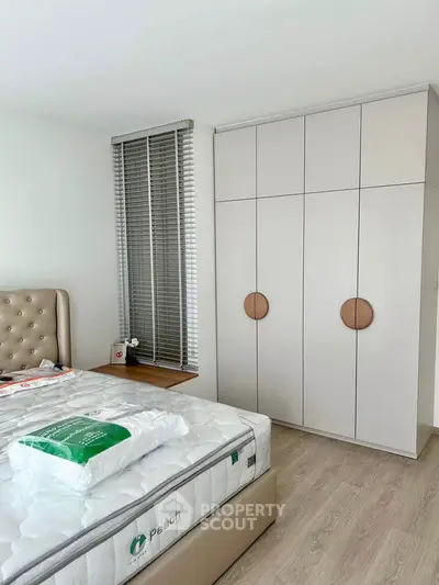 Modern bedroom with stylish wardrobe and comfortable bed in a bright, minimalist design.