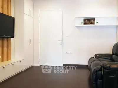 Modern living room with sleek leather sofa and wall-mounted TV