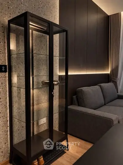 Modern living room with sleek glass cabinet and cozy gray sofa