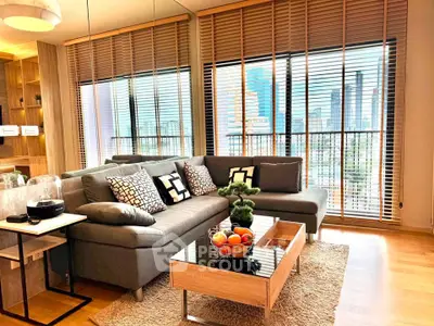 Stylish living room with modern decor and city view, featuring a cozy gray sofa and wooden accents.