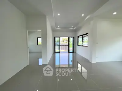 Spacious modern living room with large windows and glossy tile flooring