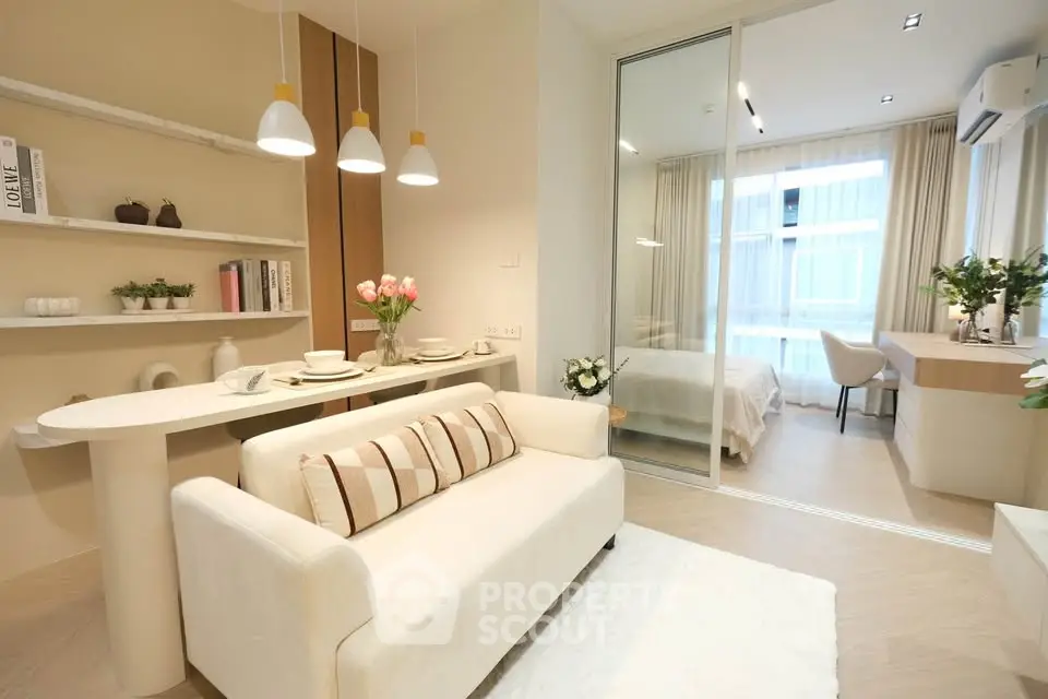Modern open-plan living room with cozy bedroom, elegant decor, and natural light.