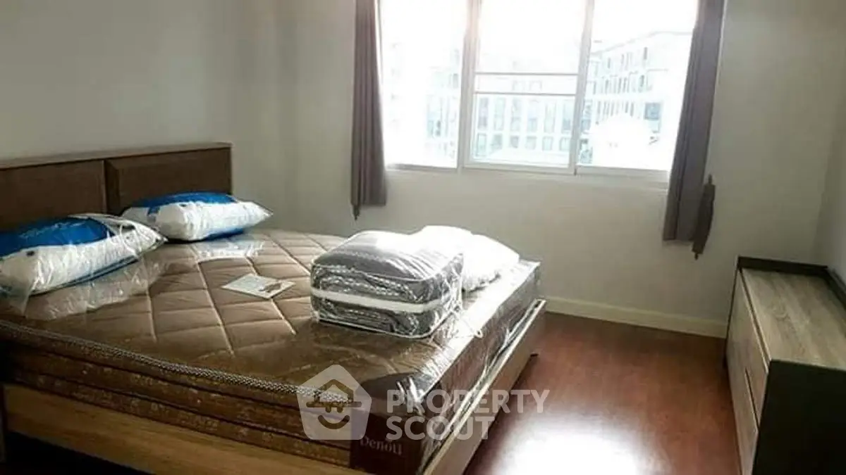 Cozy bedroom with natural light and modern furnishings, perfect for relaxation.