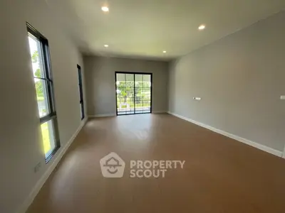 Spacious empty room with large windows and sliding glass doors, perfect for customization.