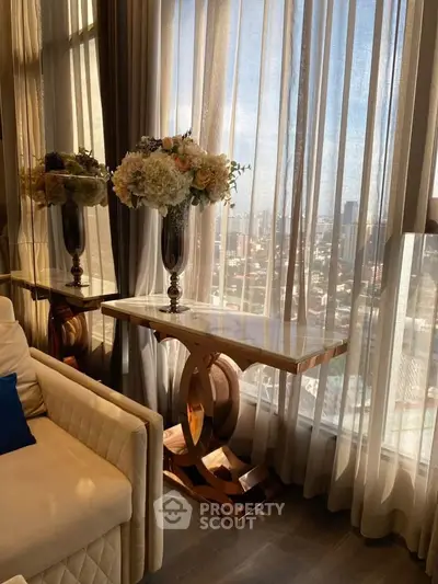 Luxurious living room with elegant decor and stunning city view through large windows.