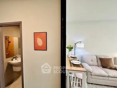 Modern apartment interior with cozy living room and adjacent bathroom, featuring stylish decor and comfortable furnishings.
