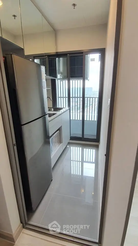 Modern kitchen with sleek appliances and city view from balcony