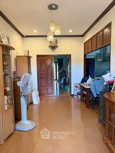 Spacious living area with elegant wooden door and modern lighting