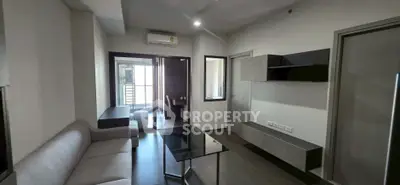 Modern living room with sleek furniture and balcony access in a stylish apartment.