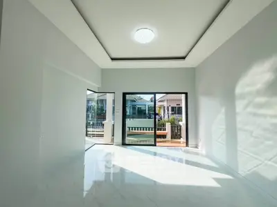 Bright and spacious living room with large windows and balcony access, perfect for modern living.