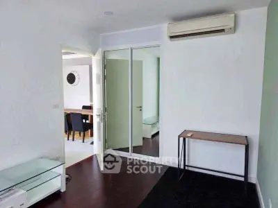 Modern living room with air conditioning and glass door leading to dining area.