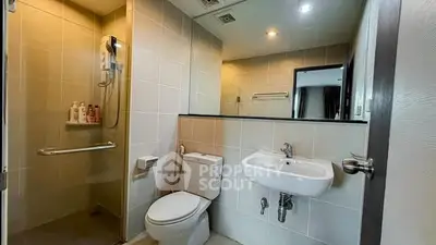 Modern bathroom with sleek fixtures and spacious shower in contemporary apartment.