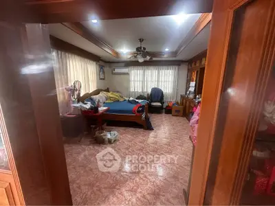 Spacious bedroom with wooden accents and natural light, featuring a cozy bed and ample storage.