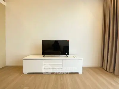 Modern minimalist living room with sleek TV stand and wooden flooring.