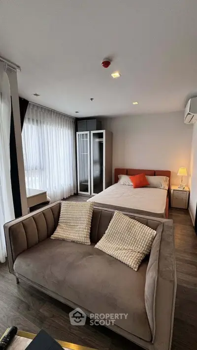 Modern bedroom with stylish sofa and large windows in a cozy apartment