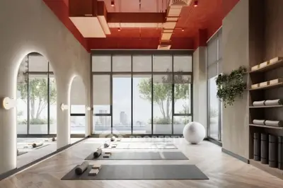 Modern yoga studio with large windows and city view, featuring mats and exercise equipment.