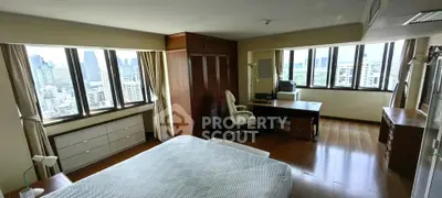 Spacious bedroom with panoramic city views and elegant wooden furnishings.