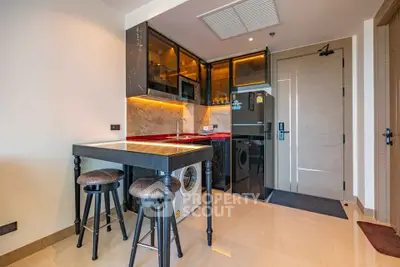 Modern kitchen with sleek appliances and stylish bar seating in a contemporary apartment.