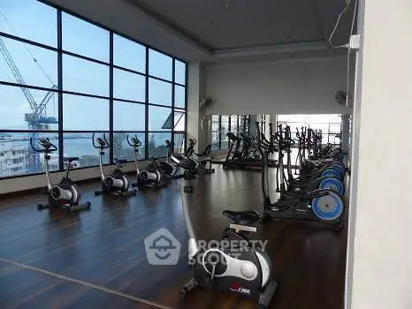 Spacious gym with modern equipment and panoramic city views.