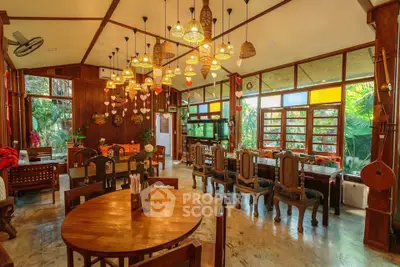 Charming rustic dining area with wooden furniture and large windows overlooking lush greenery.