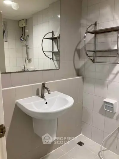 Modern bathroom with sleek sink and large mirror in a minimalist design.