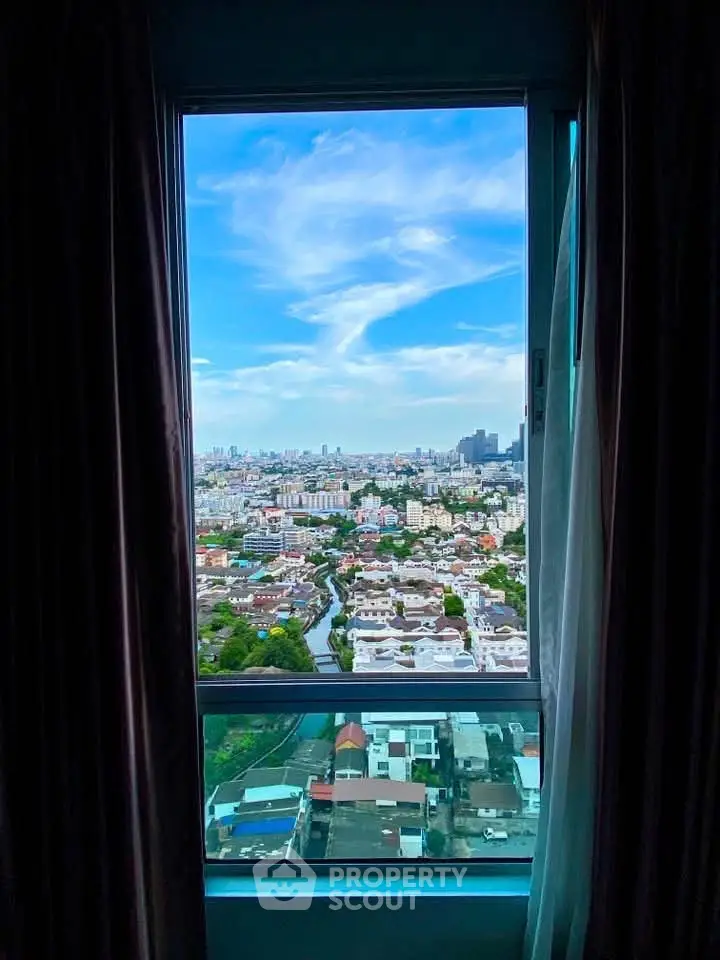Stunning cityscape view from a high-rise apartment window, showcasing urban skyline and vibrant blue sky.