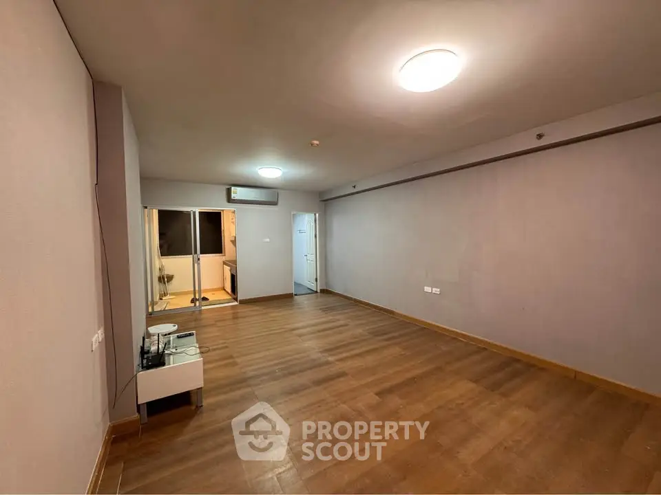 Spacious empty living room with wooden flooring and modern lighting