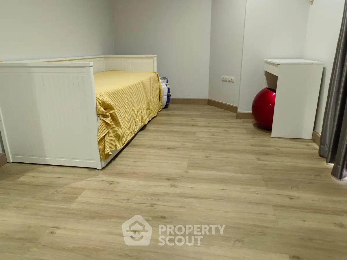 Cozy bedroom with wooden flooring and modern furniture, perfect for a comfortable living space.