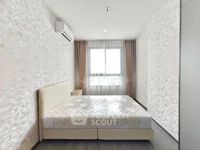 Spacious bedroom with modern decor and large window for natural light