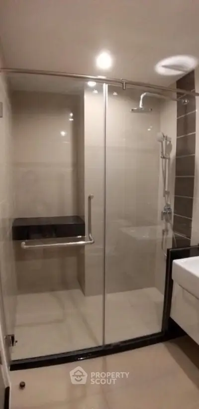 Modern bathroom with glass shower enclosure and sleek fixtures