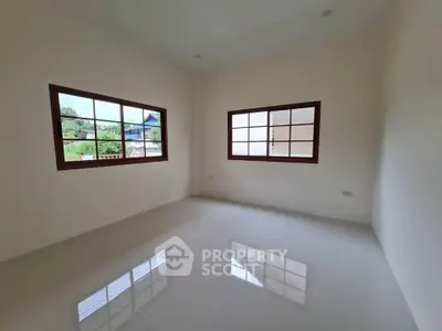 Spacious empty room with large windows and glossy tiled floor